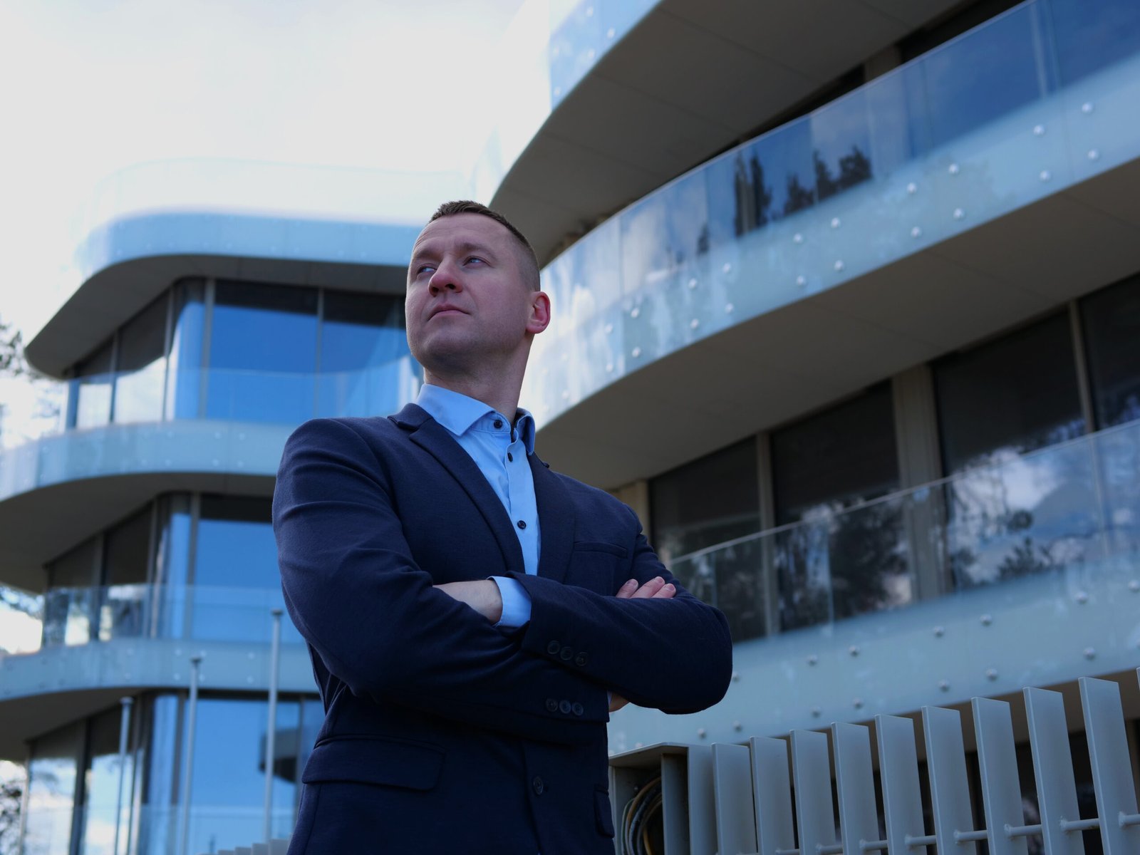 businessman adopts a confident posture hands crossed at chest. businessman displays a calm, commanding presence in elegant business attire. the stance of the businessman projects assured leadership
